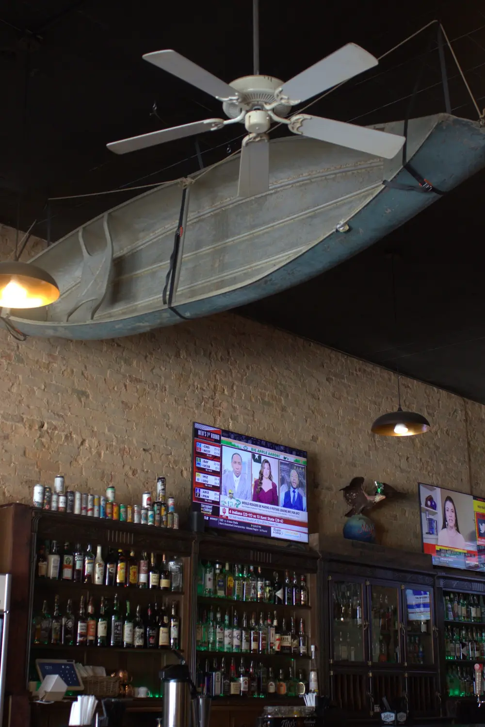 A wooden canoe mounted on the ceiling beams inside Old Towne Pub