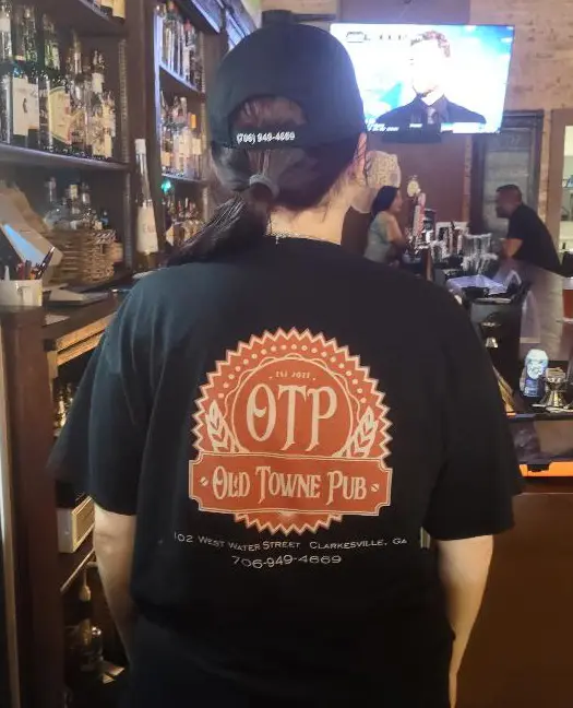 The back of a black OTP t shirt showing the Old Towne Pub seal above the pub address and phone number